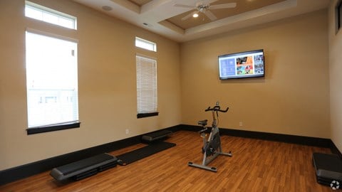 a gym with a reformer and a tv on the wall