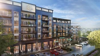 A modern apartment building with a parking lot in front.