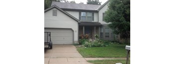 A house with a grey garage door and a mailbox on the right side.