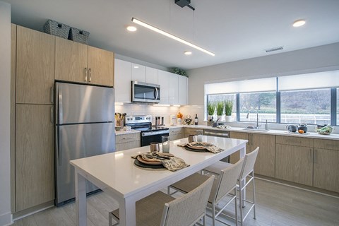 A modern kitchen with a dining table and chairs.