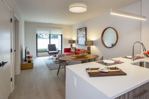 A modern kitchen with a dining table and chairs in the background.
