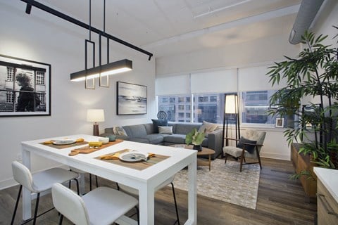 a living room and dining room in an apartment with a white table and chairs
