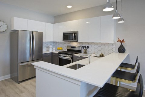 a white kitchen with stainless steel appliances and a counter top