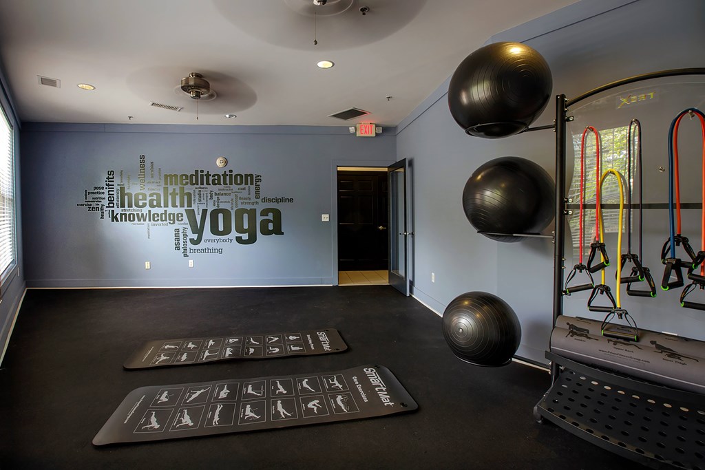 A yoga studio with a wall of words including "meditation", "health", "knowledge", and "yoga".