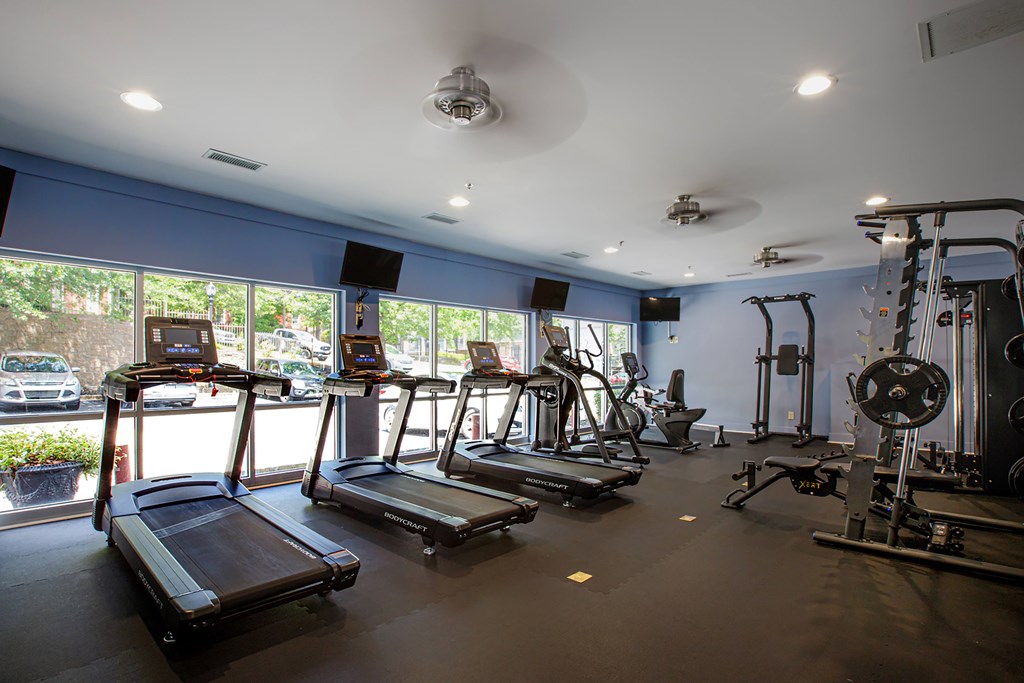 A gym with treadmills, elliptical machines, and other exercise equipment.