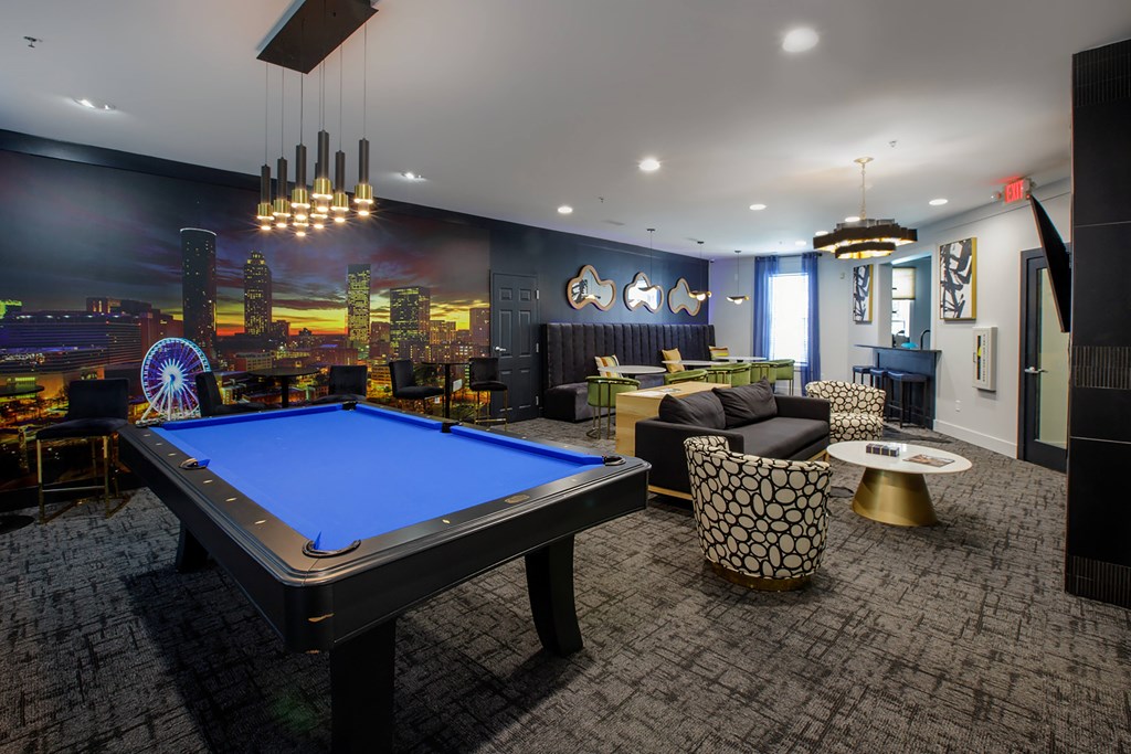 A blue pool table is in the middle of a room with a city skyline on the wall.