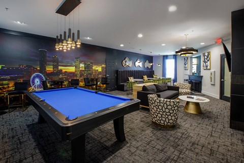 A blue pool table is in the middle of a room with a city skyline on the wall.