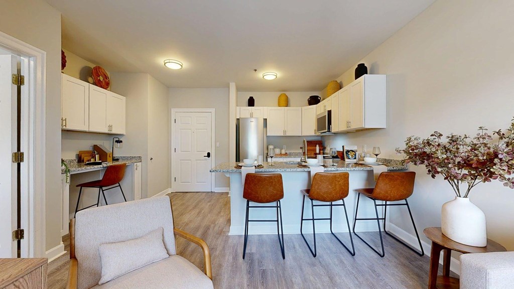 A kitchen with a bar area and chairs.