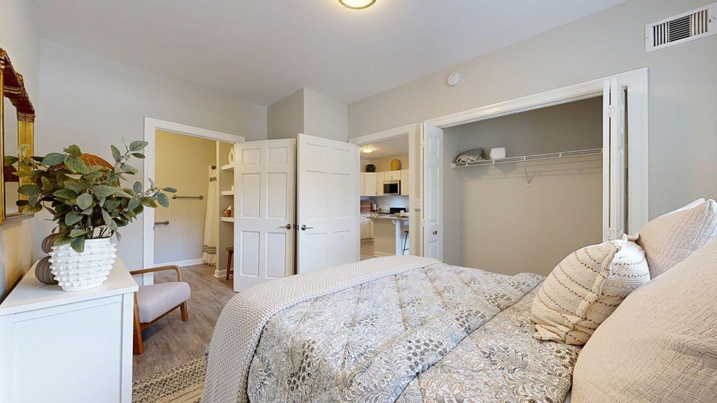 A bedroom with a bed, dresser, and mirror.