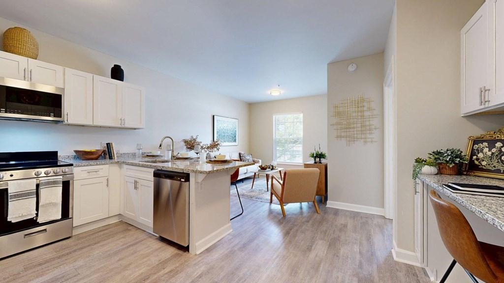 A kitchen with a stove, oven, and a dining table with chairs.