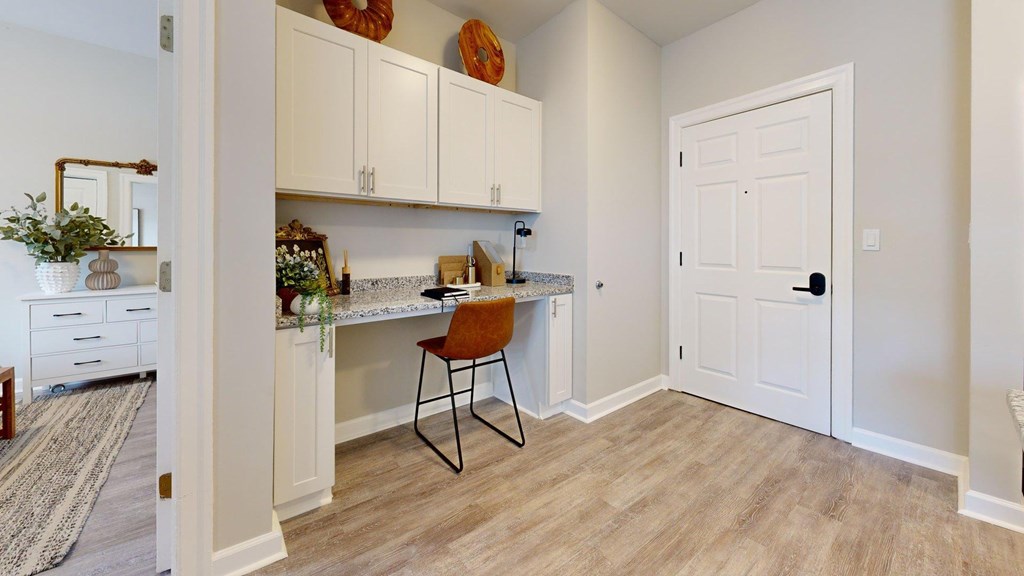 A kitchen with a white door and a brown chair.