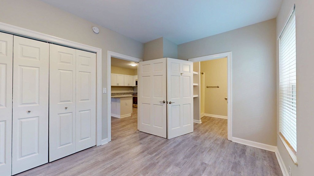A room with white doors and a grey floor.