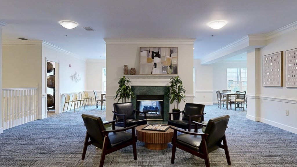 A living room with a fireplace and chairs.