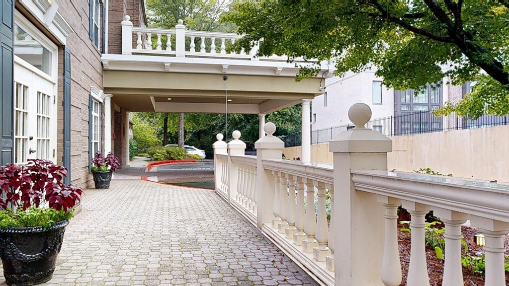 A white balustrade runs along the edge of a brick patio.
