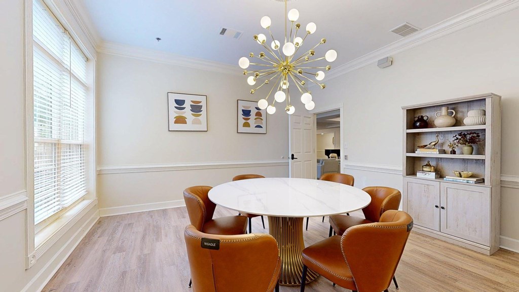 A dining room with a round table and chairs.