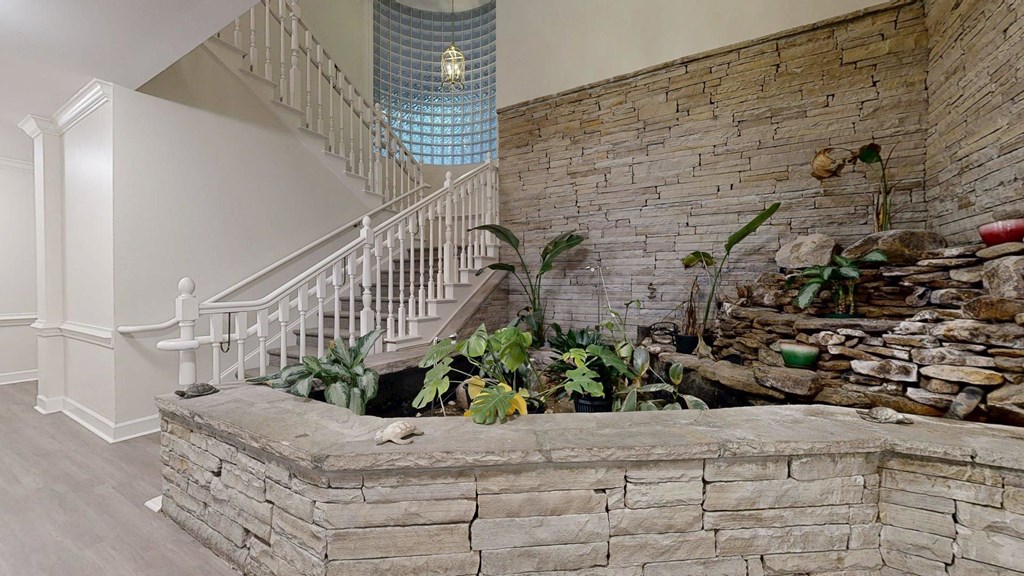 A staircase with a glass ceiling and a stone wall.