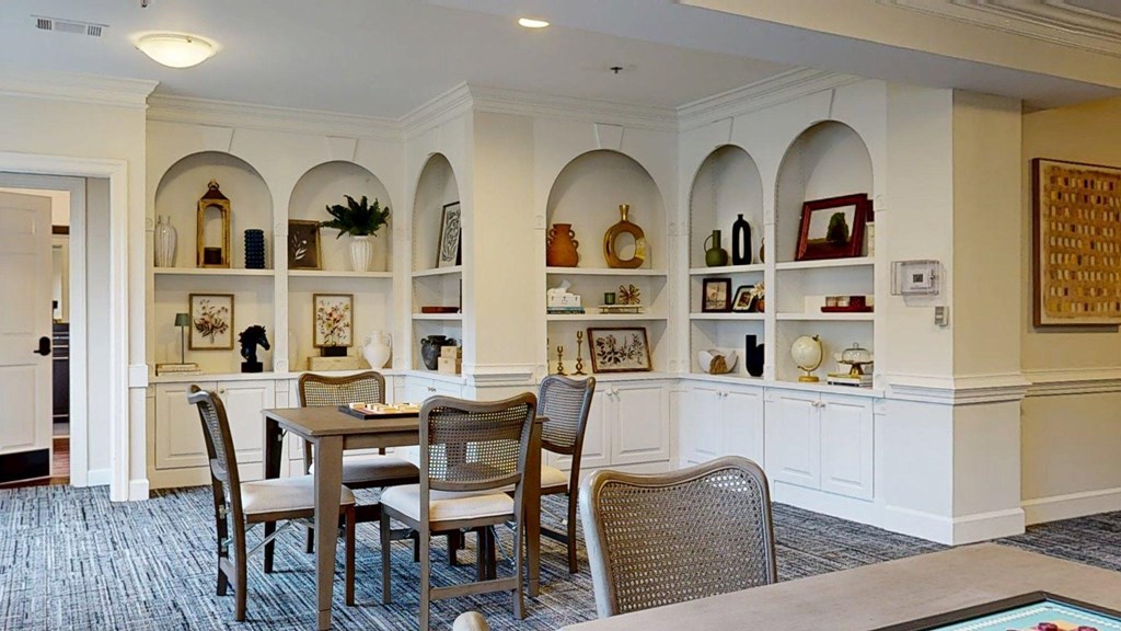 A dining room with a table and chairs.