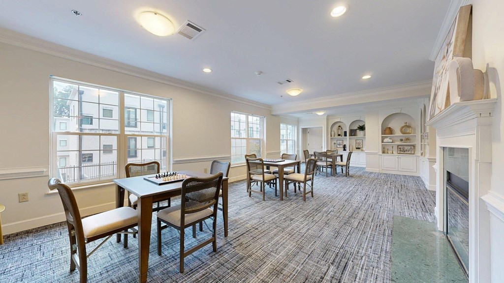 A large dining room with a fireplace and a long table.