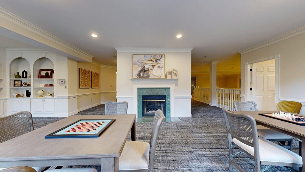 A room with a fireplace and a chess board on the table.
