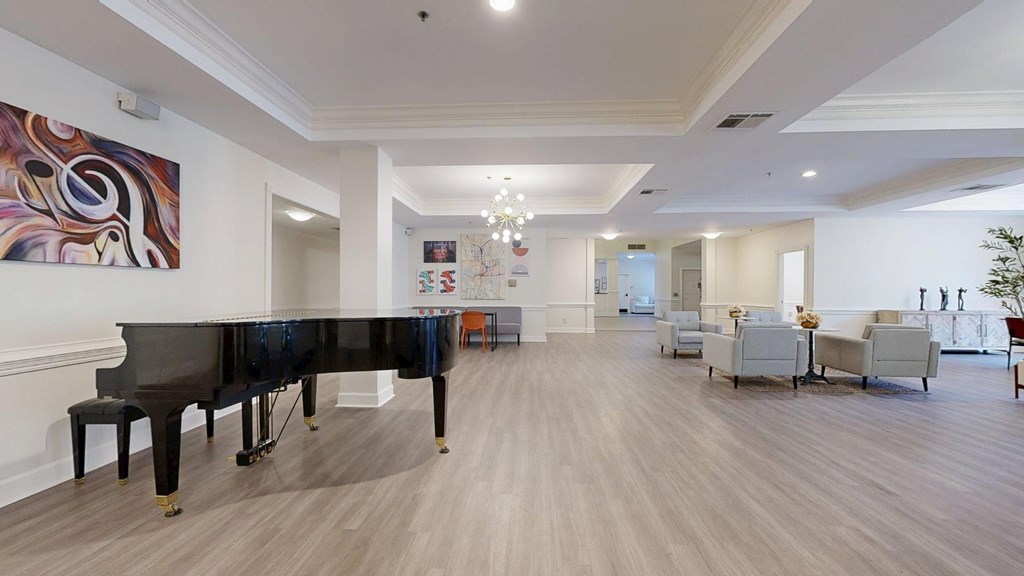 A grand piano is in the middle of a spacious room.