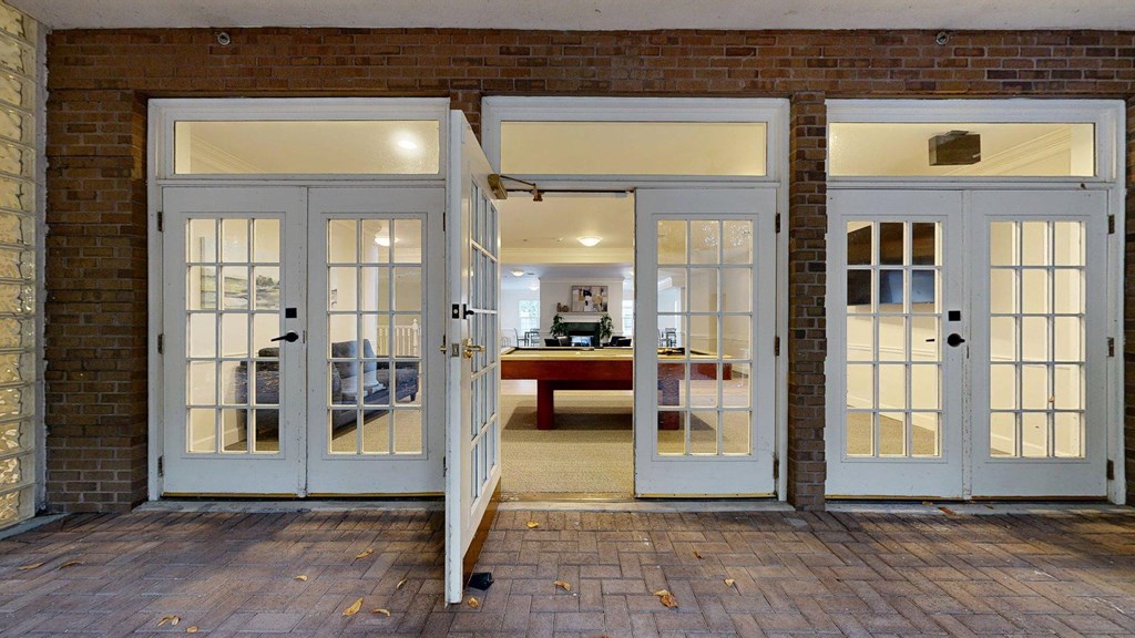 A set of double doors open to a room with a couch and a table.