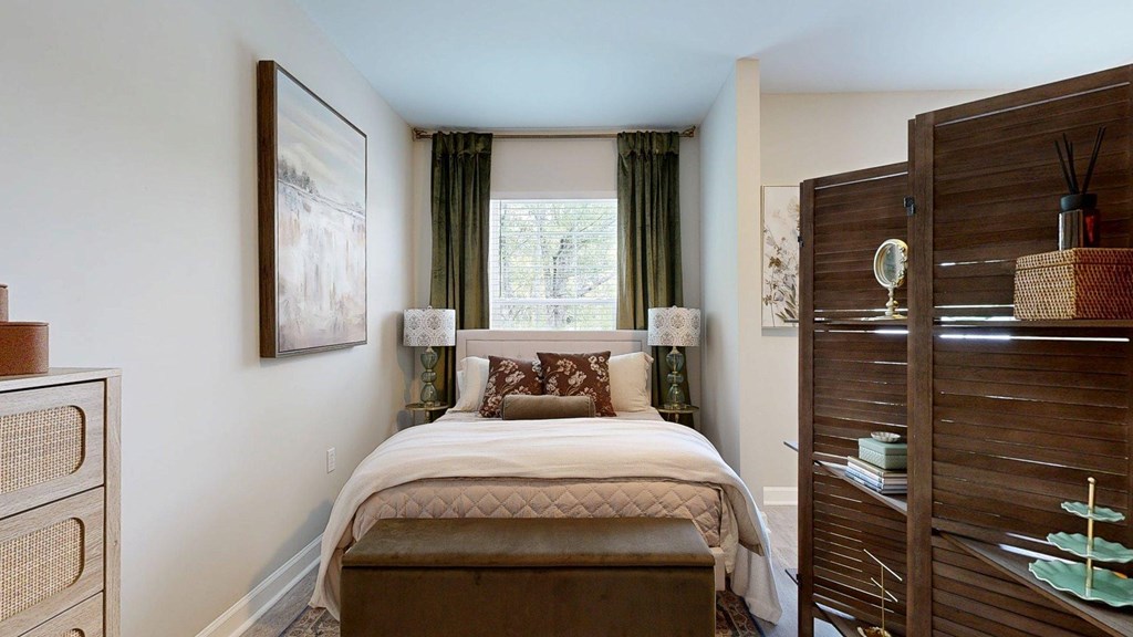 A bedroom with a large bed and a wooden wardrobe.