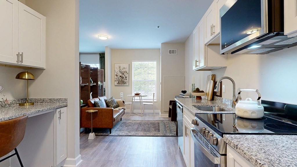 A modern kitchen with a dining area in the background.