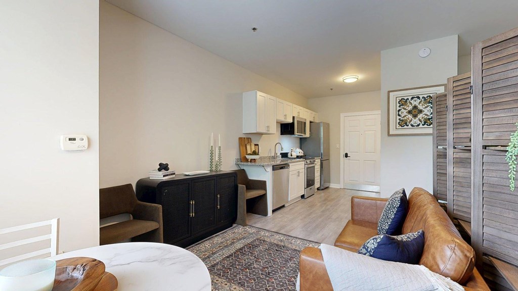 A living room with a brown leather couch and a white table.