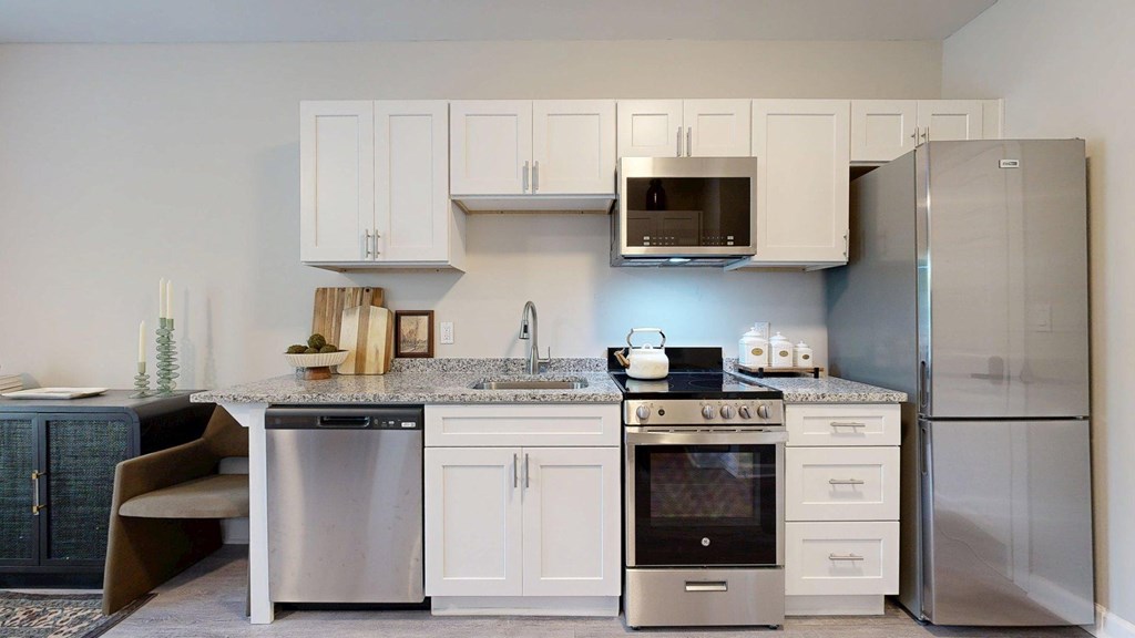 A modern kitchen with white cabinets and stainless steel appliances.