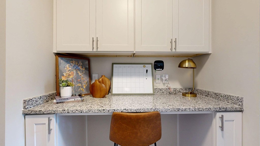 A kitchen counter with a white fridge and a brown chair.