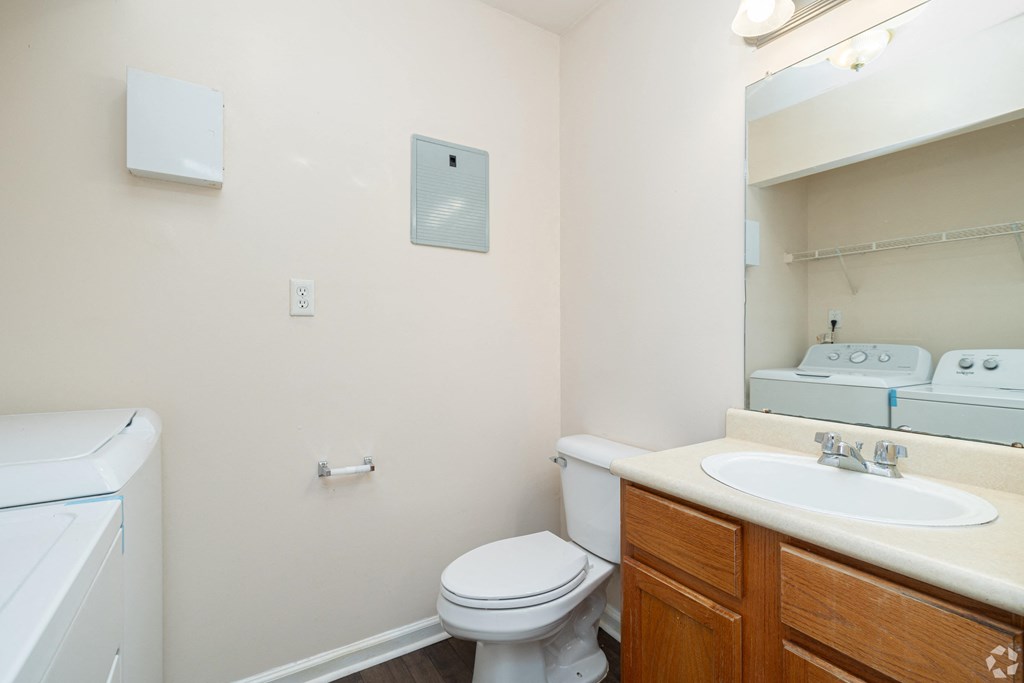 A white toilet sits next to a sink in a small bathroom.