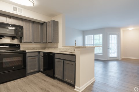 A kitchen with a black oven and microwave.