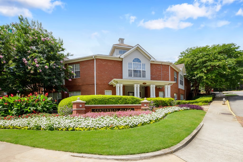A brick house with a flower bed in front of it.