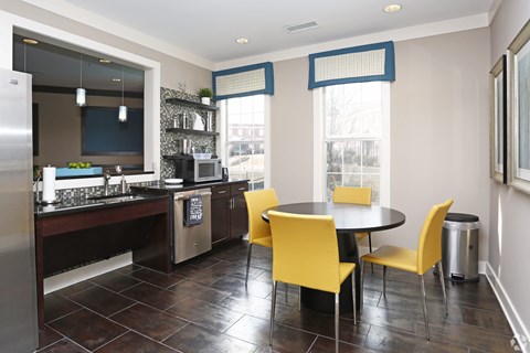 A kitchen with a table and chairs.
