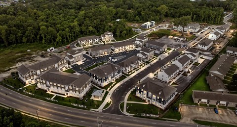 A bird's eye view of a residential area with multiple houses and a road.