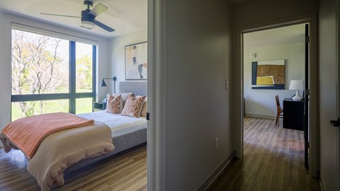 A bedroom with a bed and a ceiling fan.