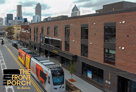A train is on a track in front of a building.