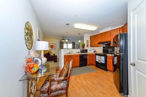 A kitchen with wooden cabinets and a black fridge.
