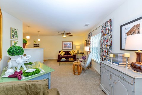 A living room with a green table and a white elephant statue.