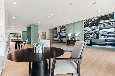 a dining room with a table and chairs in front of a wall mural of cars