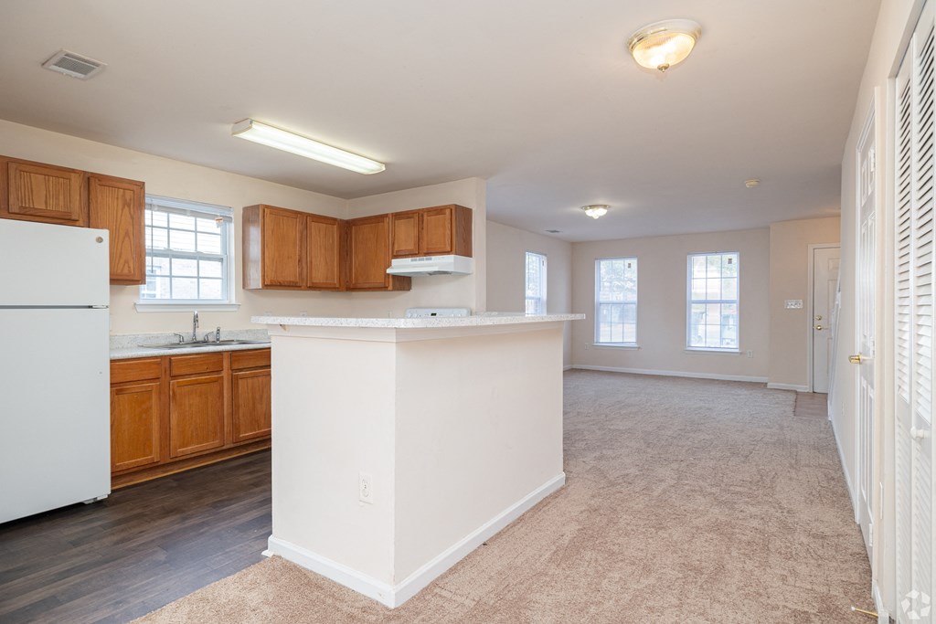 A kitchen with white appliances and wooden cabinets.