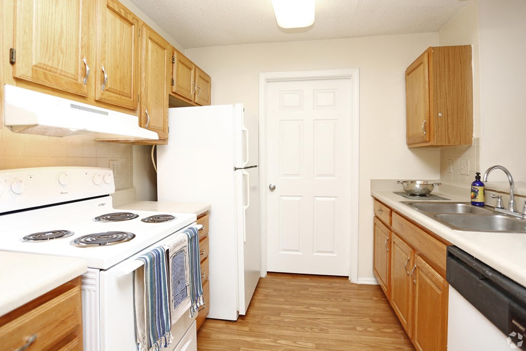 A kitchen with wooden cabinets and a white refrigerator.