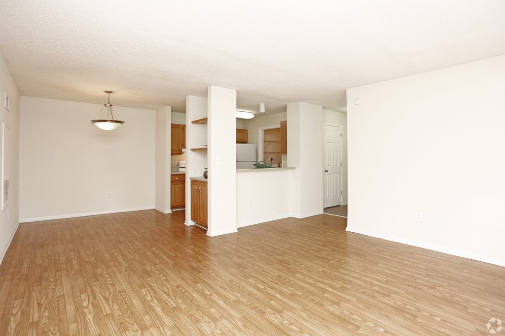 A room with wooden flooring and white walls.