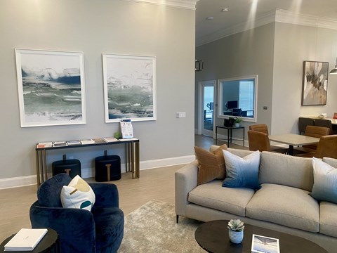 A living room with a blue chair and a beige couch.