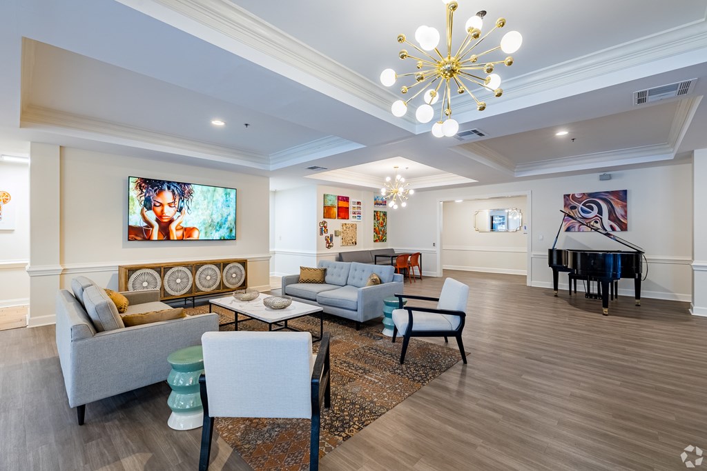 A living room with a piano and a chandelier.