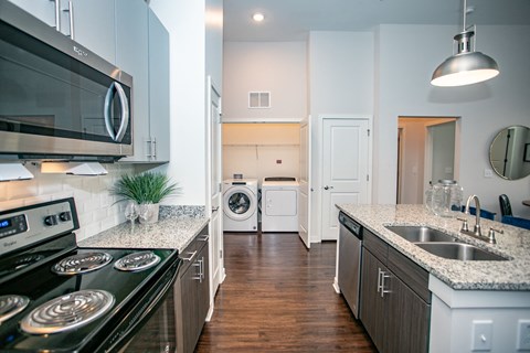 A modern kitchen with a black stove top oven and a white microwave above it.