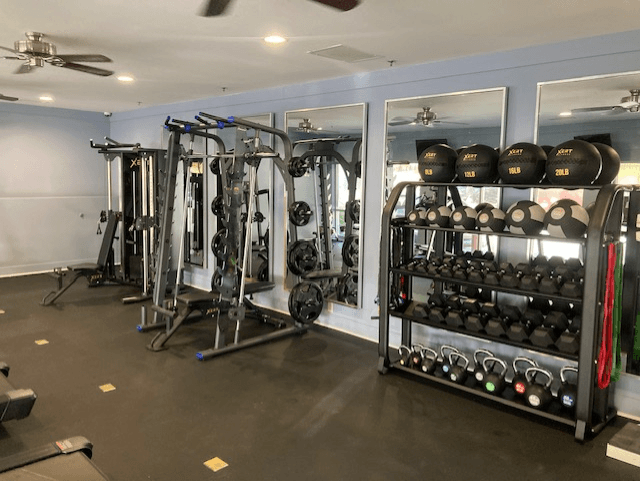 A gym with a variety of equipment including weights and machines.