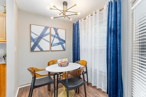 A dining room with a white table and chairs.