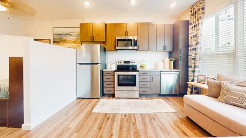 A modern kitchen with wooden cabinets and stainless steel appliances.