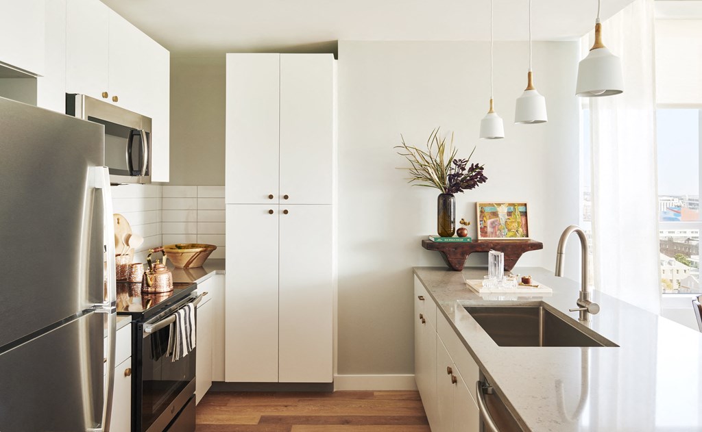 a kitchen with white cabinets and stainless steel appliances and a sink